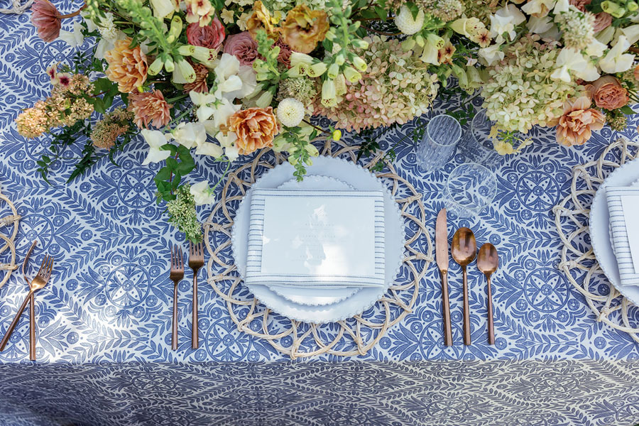 Close up of table setting with blue table cloth and flowers