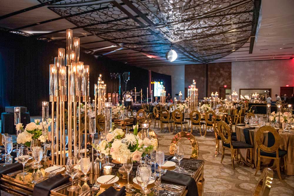 elaborately decorated tables with gold chairs in a dim room