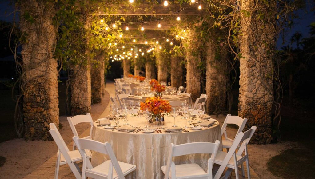 Banner image with round tables with columns on either side and twinkle lights overhead